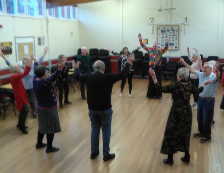 Disco dancers in a ring doing YMCA